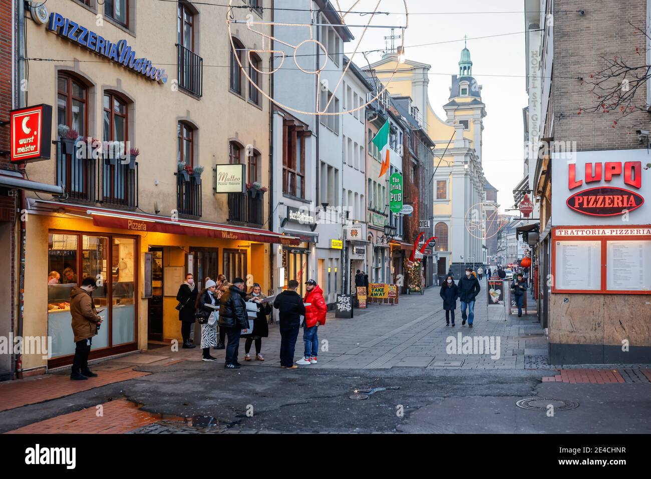 Duesseldorf, North Rhine-Westphalia, Germany - Empty old town of Duesseldorf with Santa Claus in times of the corona crisis during the second part of lockdown, passers-by eat their takeaway pizza on the street. Stock Photo