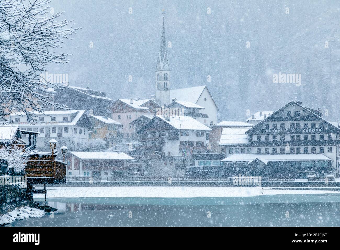Italy, Veneto, province of Belluno, Agordino, Dolomites, the village of Alleghe on the lake under a snowfall Stock Photo