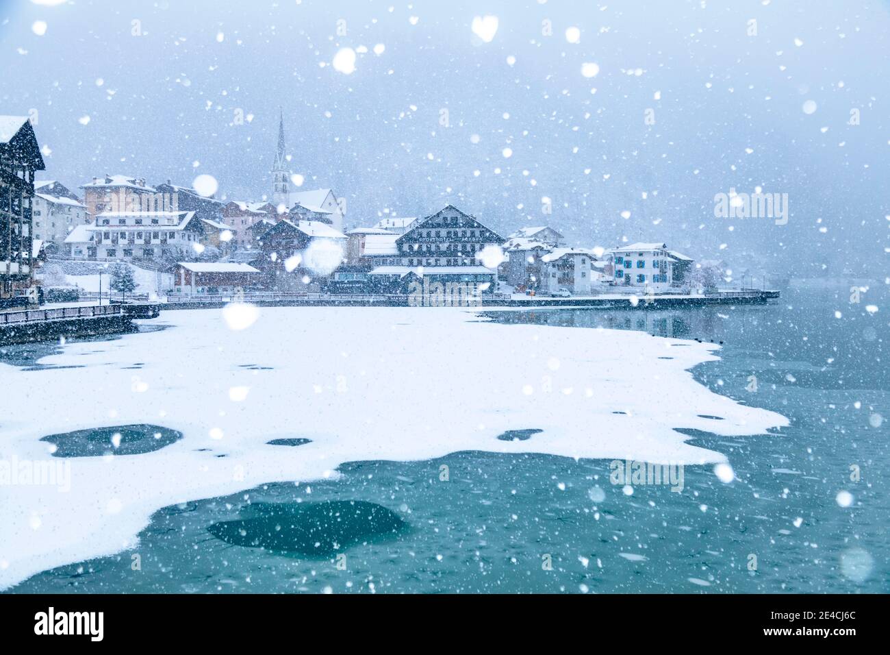 Italy, Veneto, province of Belluno, Agordino, Dolomites, the village of Alleghe on the lake under a snowfall Stock Photo