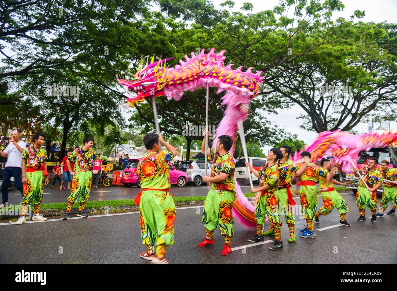 young men in New Year parade with dragon dance Stock Photo