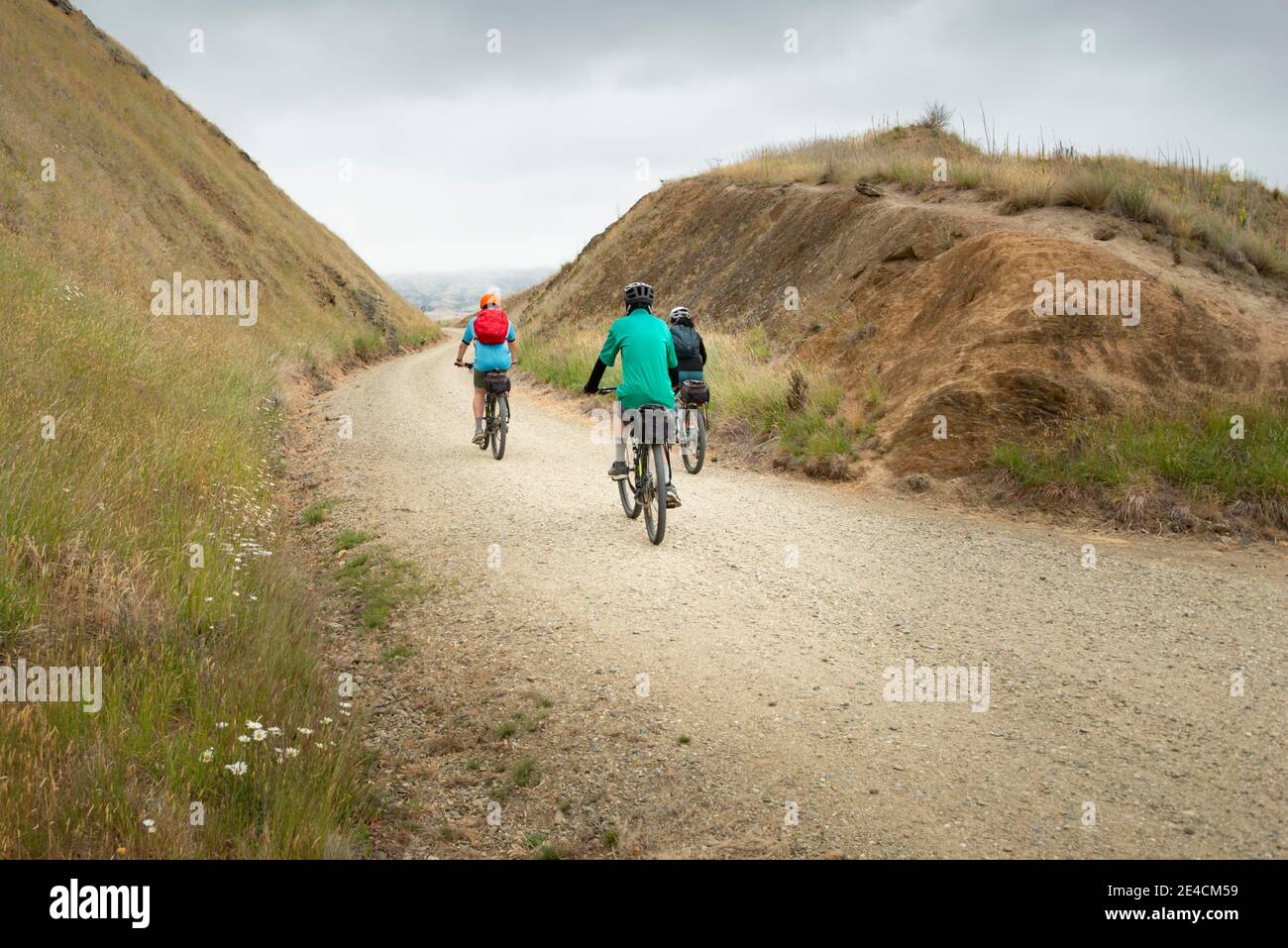 Three people cycling the Otago Central Rail Trail at Poolburn Gorge, South Island Stock Photo