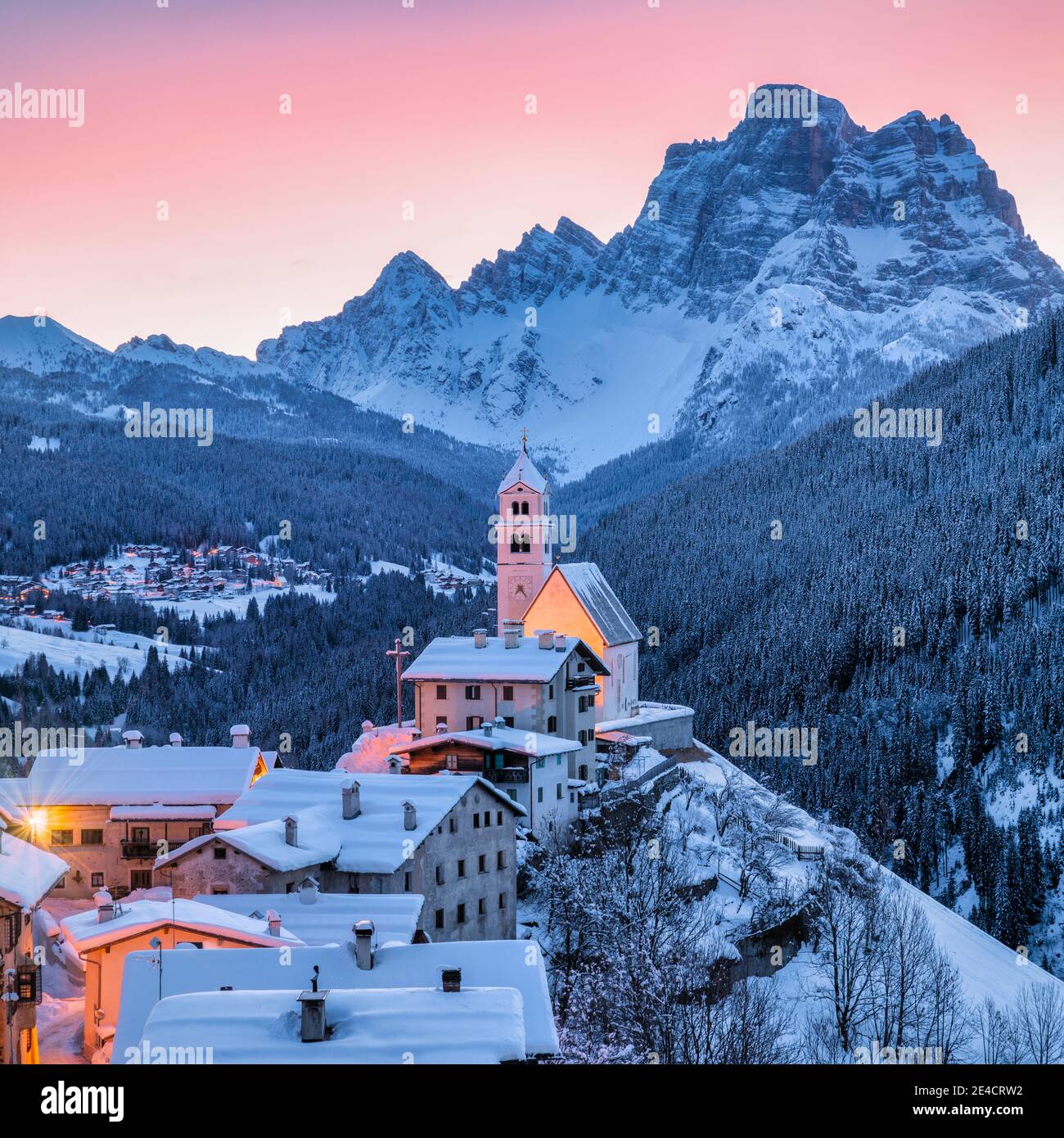 Italy, Veneto, Belluno, Agordino, alpine village of Colle Santa Lucia in winter at dawn, illuminated houses and church, Dolomites Stock Photo