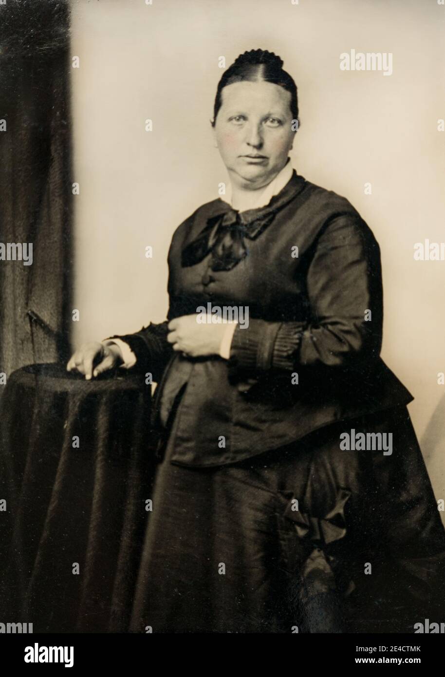 American archive monochrome portrait  on tintype plate of a woman in a a black dress with eretouched hand painted pink tint. Taken late 19th century, NY, USA Stock Photo