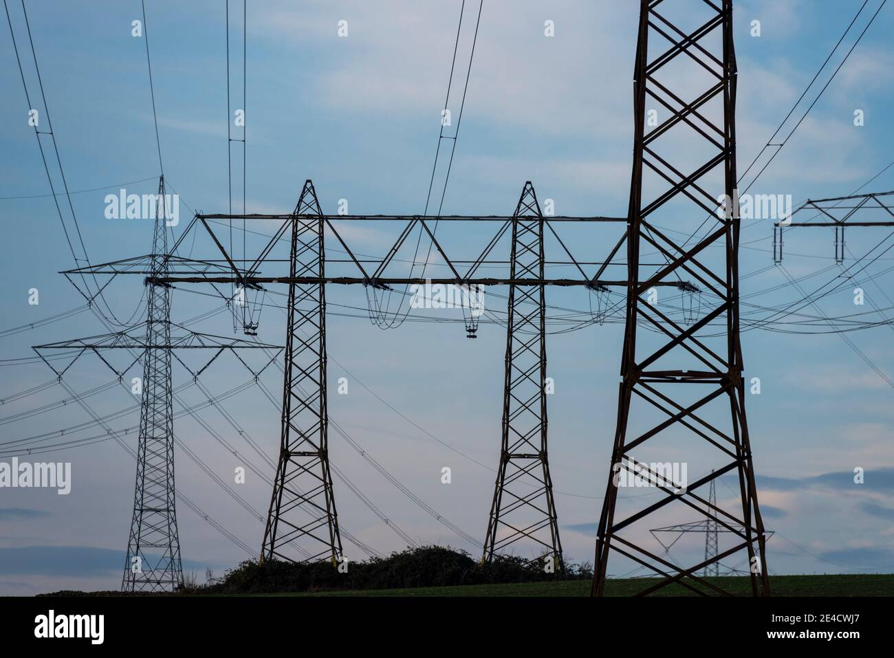 Electricity pylons are on a hill Stock Photo