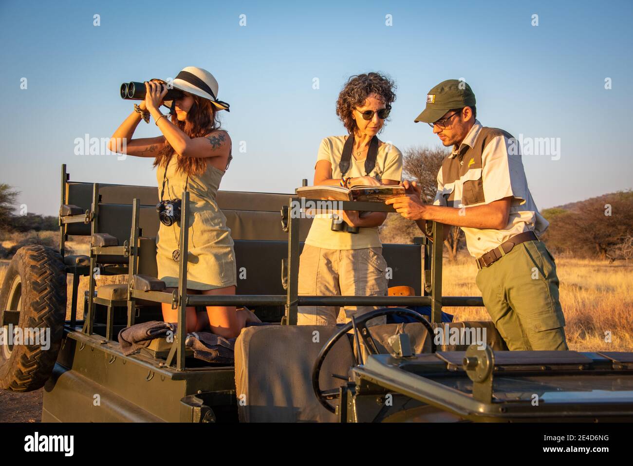 Guide and two female guests discuss sighting Stock Photo - Alamy