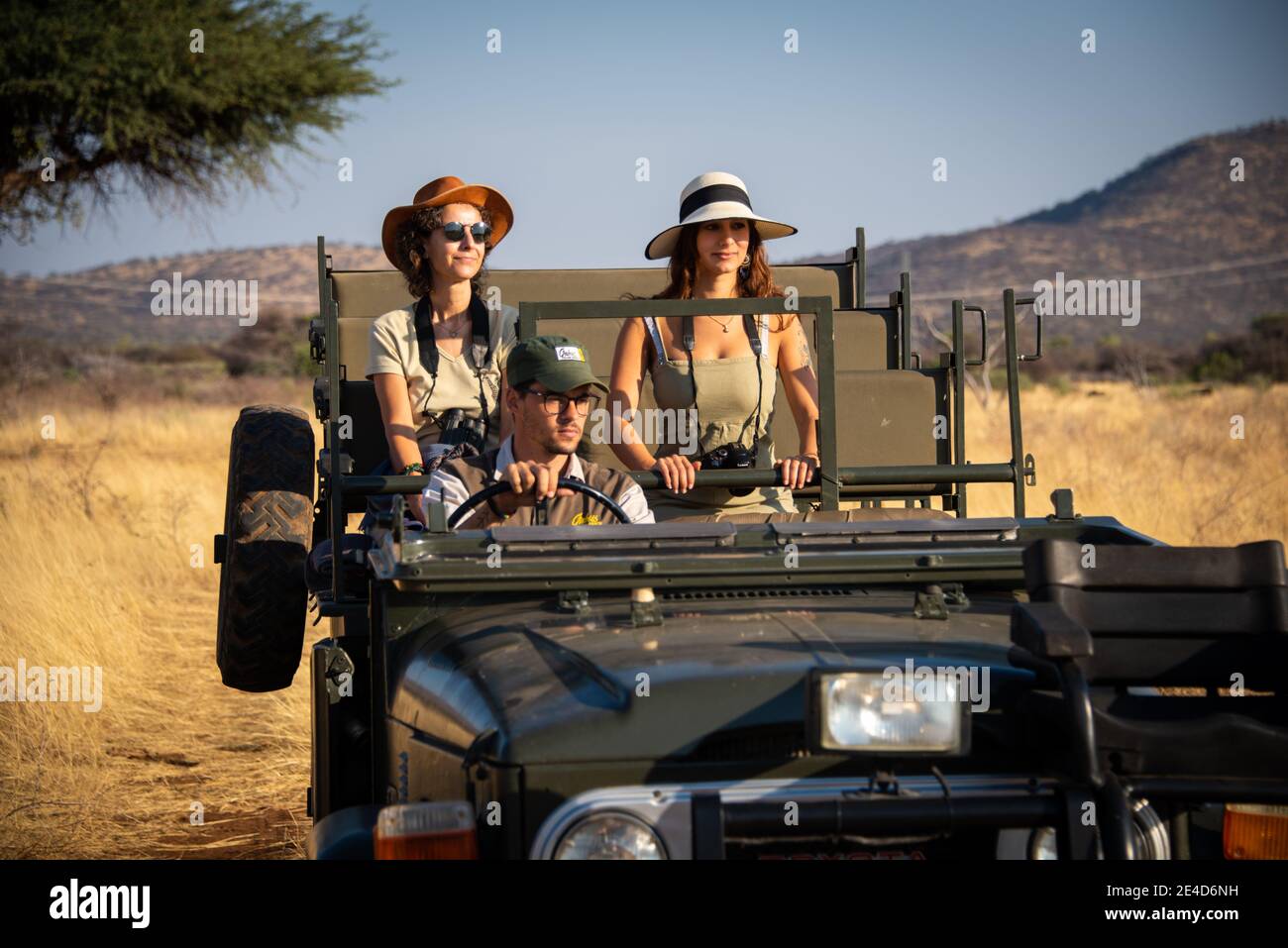 Guide drives two female guests in grassland Stock Photo - Alamy