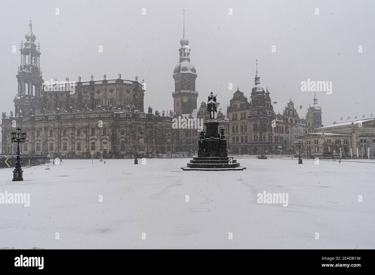 Dresden, Germany. 23rd Jan, 2021. It snows in the morning on the Theaterplatz with the Hofkirche (l-r), the Hausmannsturm, the equestrian statue of King Johann, the Residenzschloss and the Schinkelwache. Credit: Robert Michael/dpa-Zentralbild/dpa/Alamy Live News Stock Photo