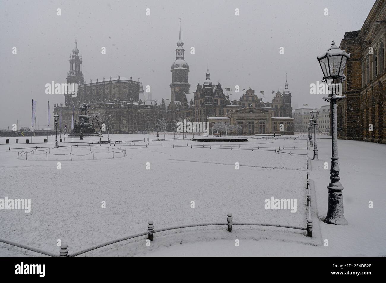 Dresden, Germany. 23rd Jan, 2021. It snows in the morning on the Theaterplatz with the Hofkirche (l-r), the equestrian statue of King Johann, the Hausmannsturm, the Residenzschloss, the Schinkelwache and the Zwinger. Credit: Robert Michael/dpa-Zentralbild/dpa/Alamy Live News Stock Photo