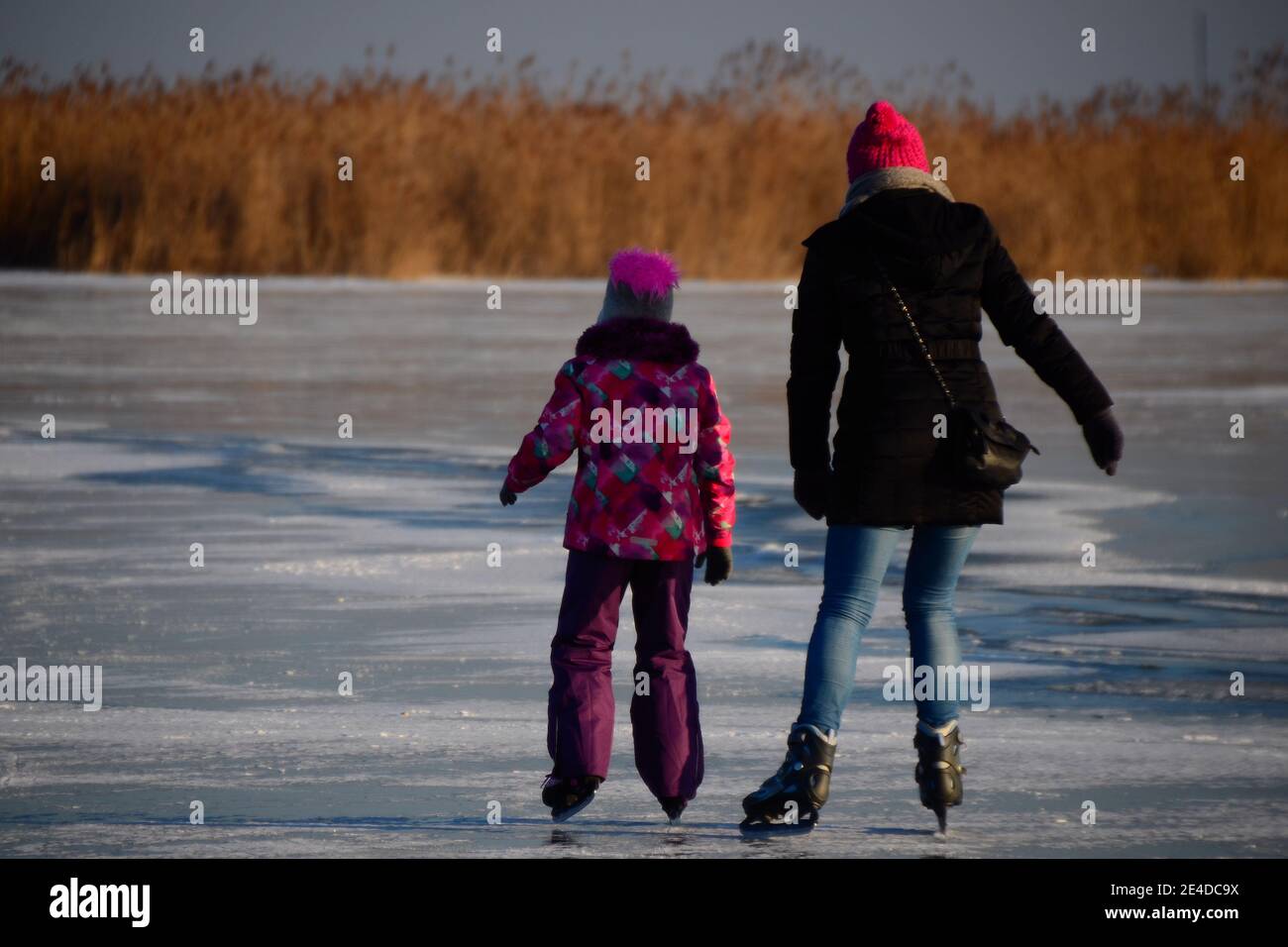 Mother and daughter ice skating on the lake Stock Photo