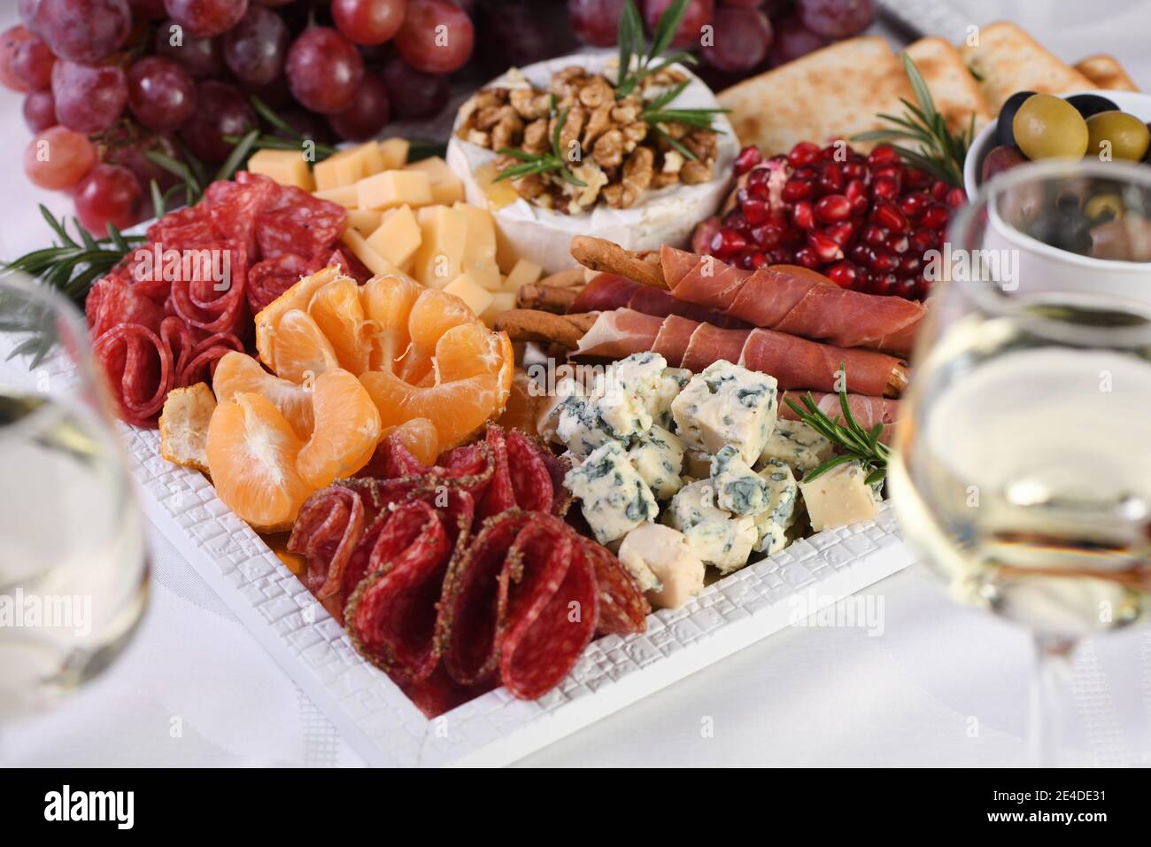 Delicacy assorted appetizer platter of salami and cheese, grissini wrapped  in Parma ham, olives and citrus fruits. An original antipasto serving for a  Stock Photo - Alamy