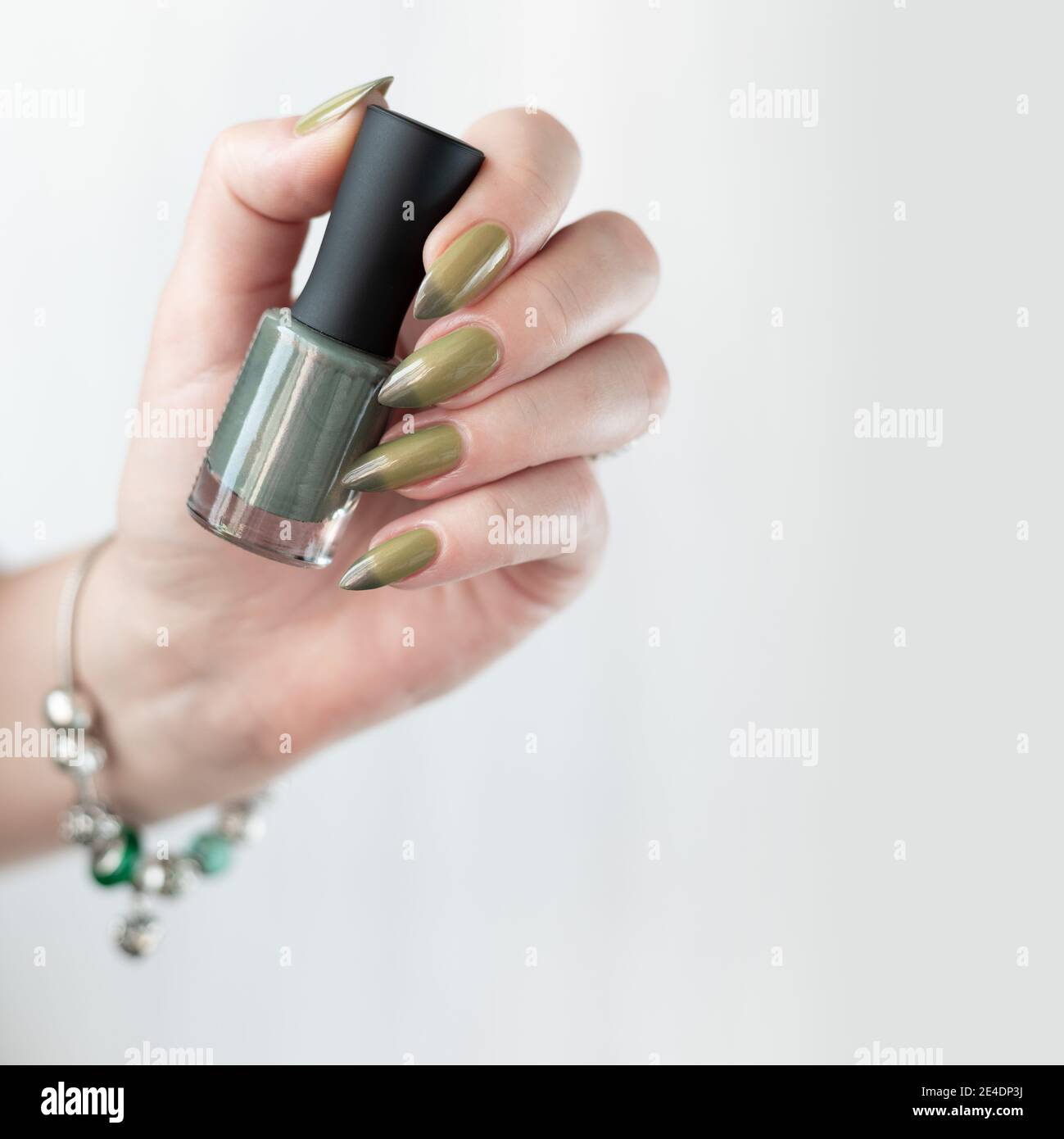 Woman S Hand With Long Nails And Light And Dark Green Manicure With Bottles Of Nail Polish Stock Photo Alamy