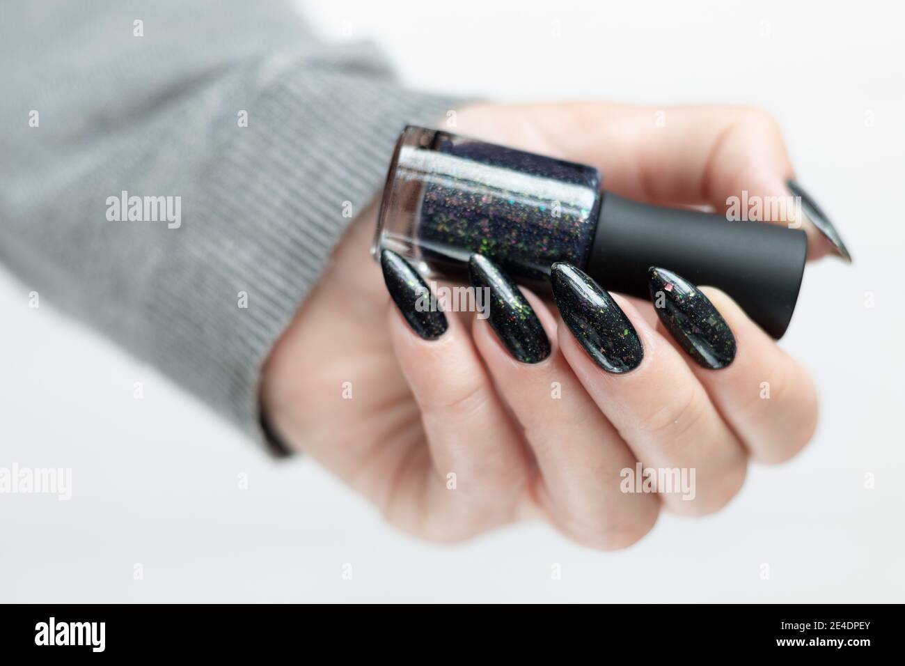 Female Hand With Long Nails And Black Gray Manicure Holds A Bottle Of Nail Polish Stock Photo Alamy