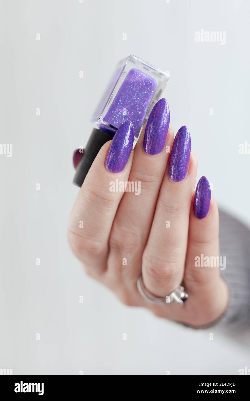Female hand with purple long nails and nail polish bottle Stock Photo -  Alamy