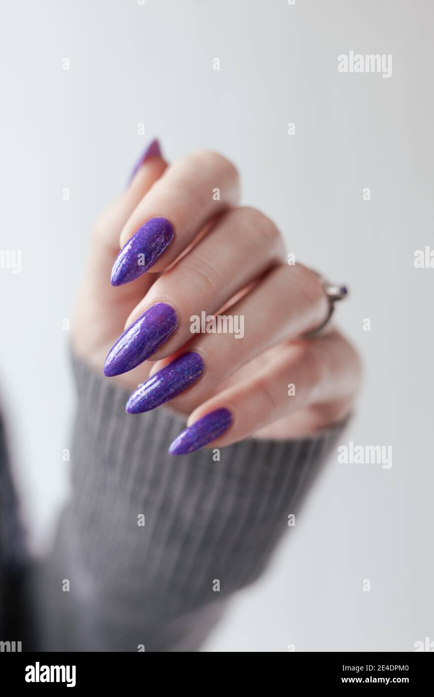 Female hand with purple long nails and nail polish bottle Stock Photo -  Alamy