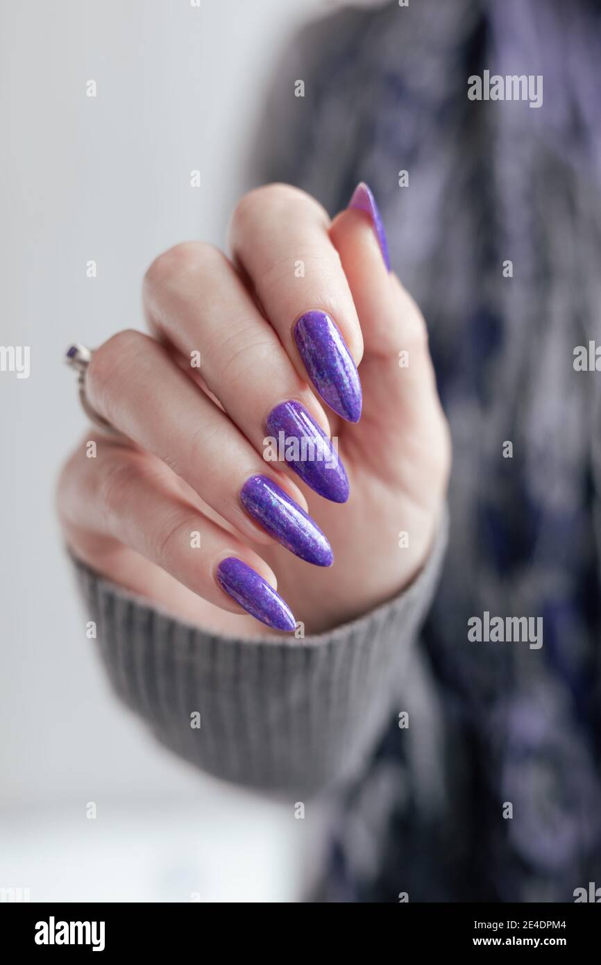 Female hand with purple long nails and nail polish bottle Stock Photo -  Alamy