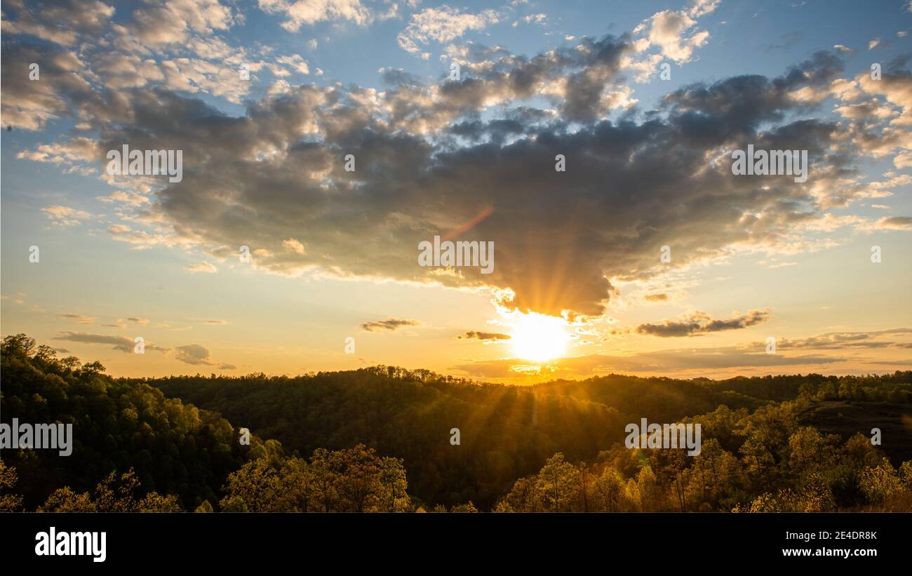 The sun sets as dark clouds approach. Stock Photo