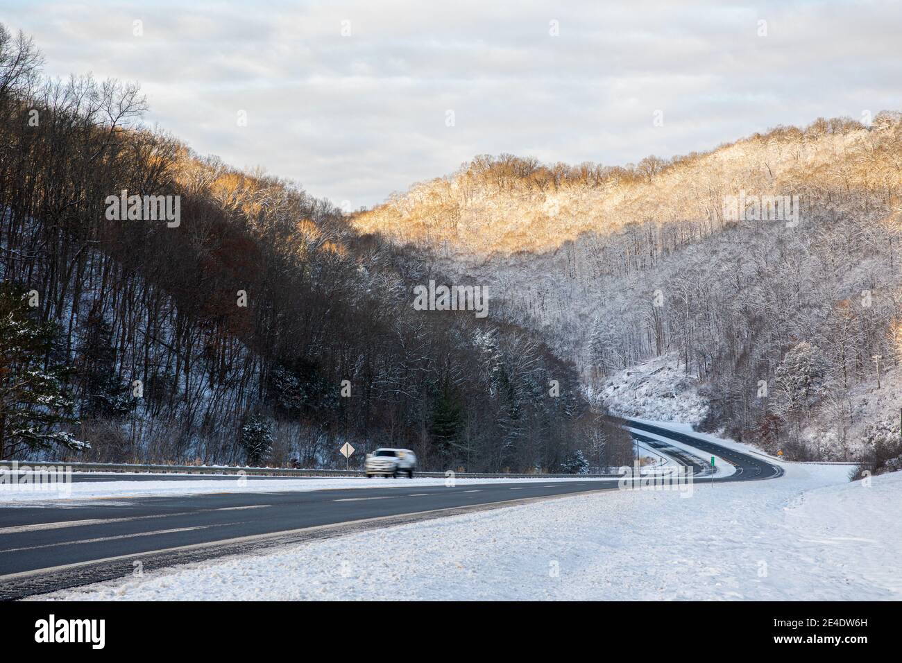 A rural, mountainous road winds through the Appalachian foothills of Eastern Kentucky in winter. Stock Photo