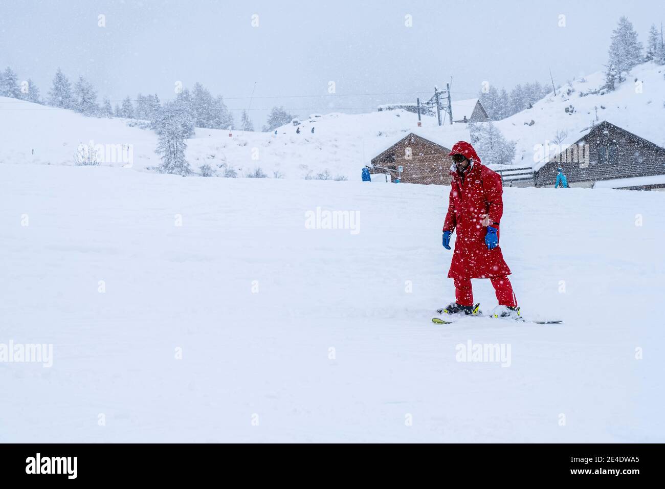 Auron, France - 01.01.2021: Professional ski instructor skiing on the ski track during snowfall. Blurred focus background. Stock Photo