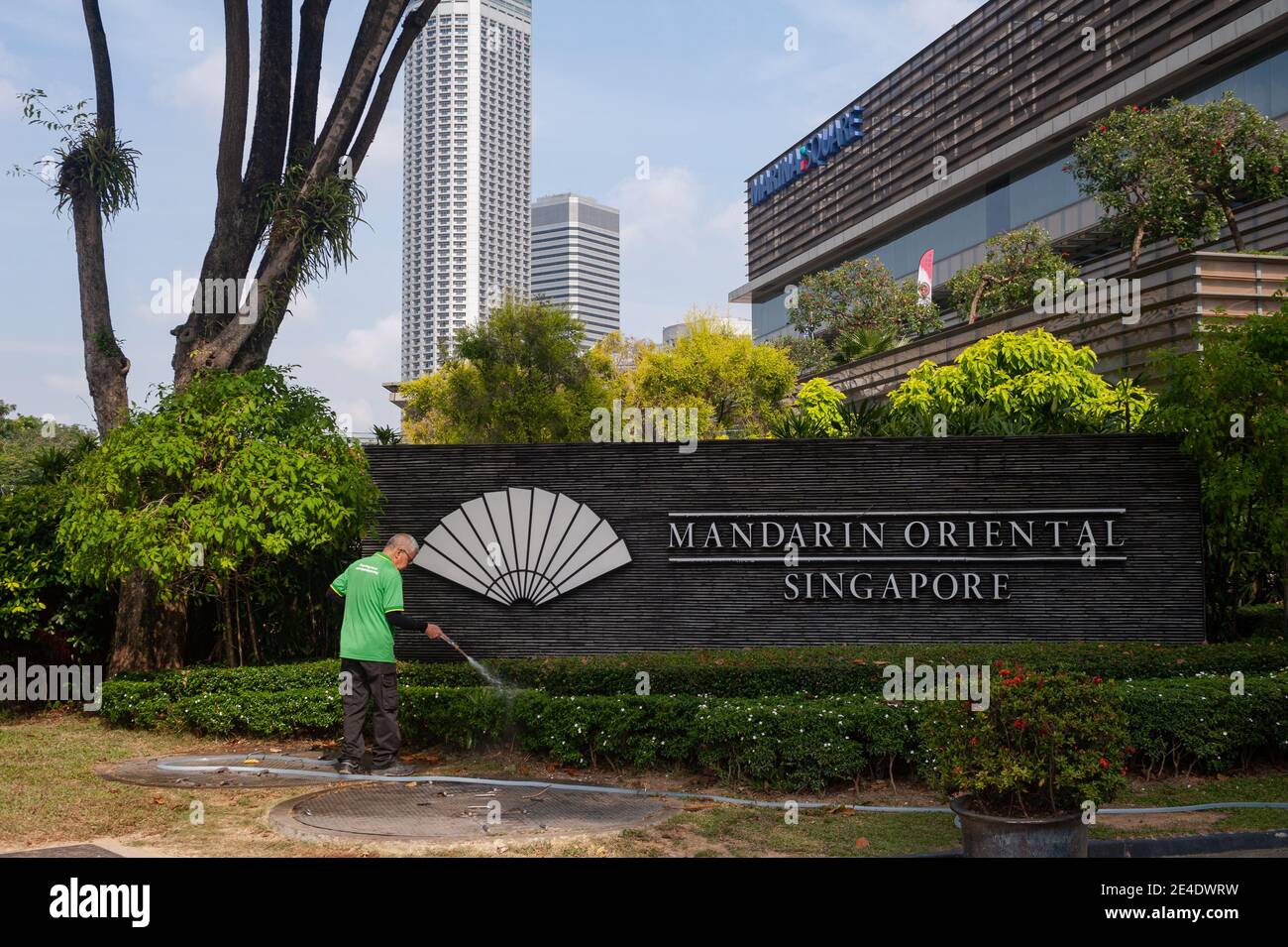 21.01.2021, Singapore, Republic of Singapore, Asia - A worker waters the plants at the Mandarin Oriental Singapore Hotel, Marina Square. Stock Photo