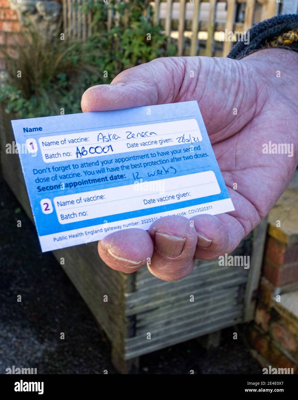 Male holding Covid 19 Vaccination Card Stock Photo