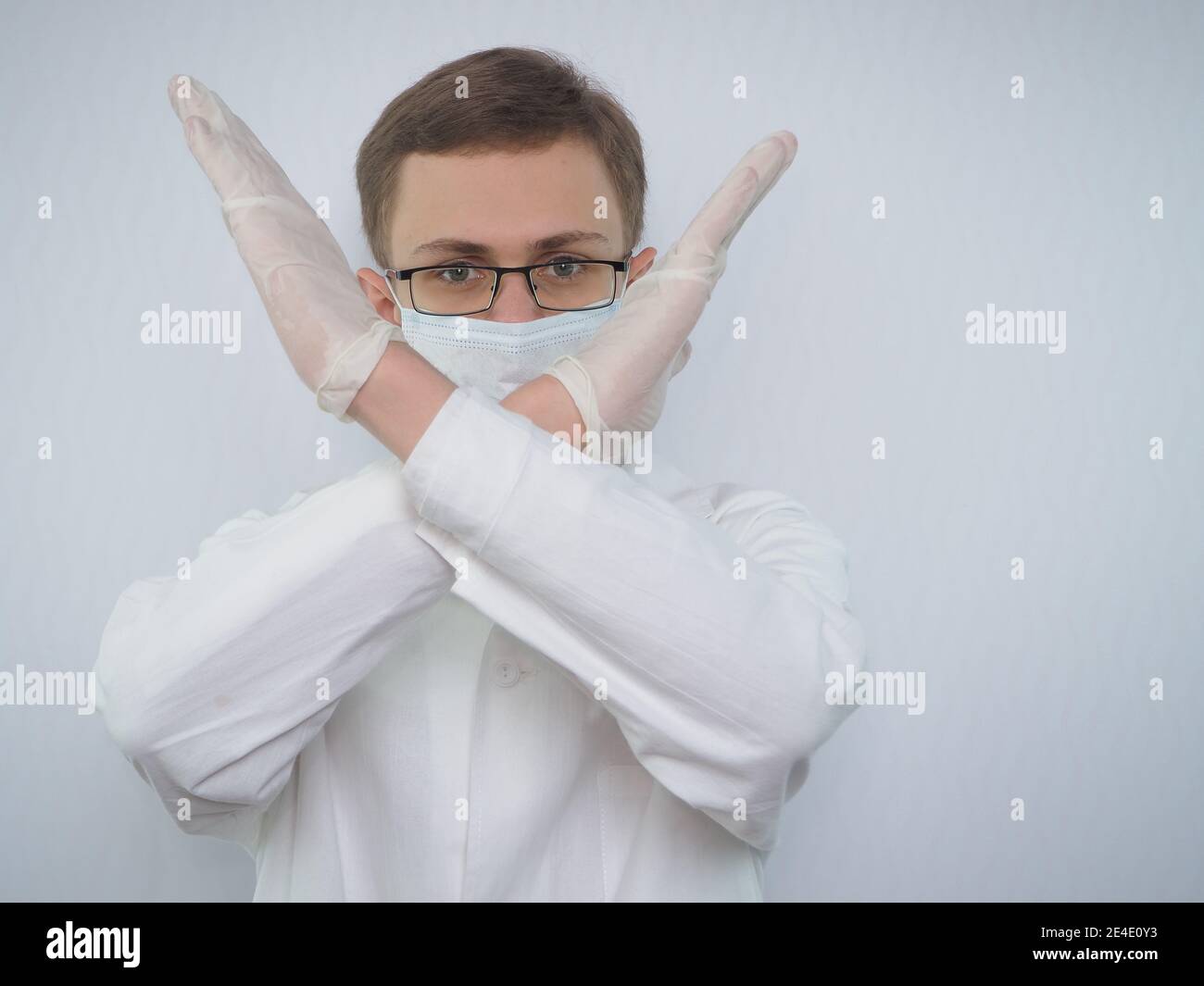 Portrait of a young man of European appearance in a medical white coat ...