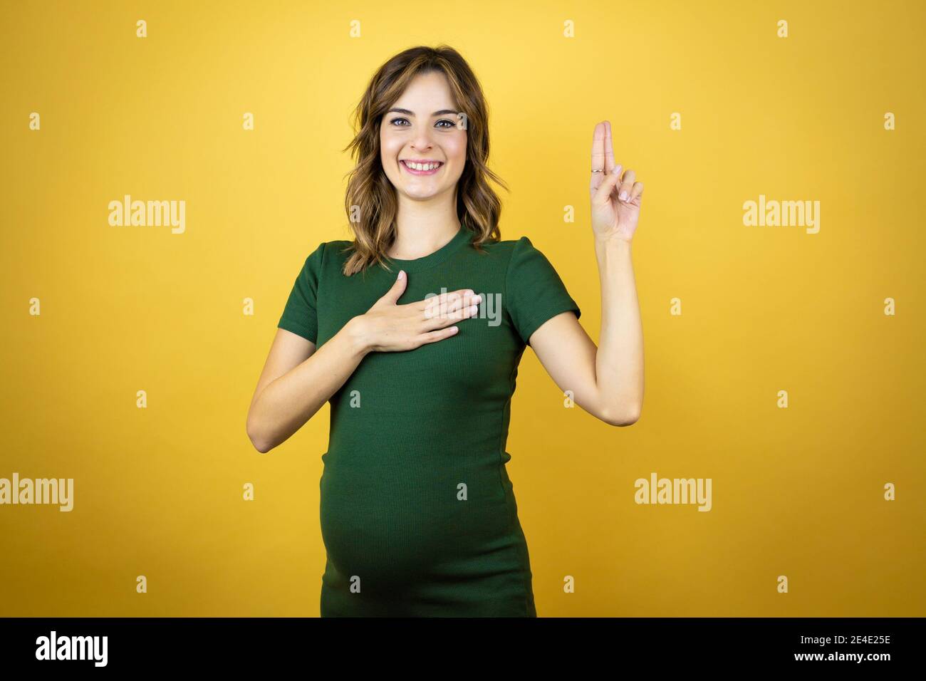 Young beautiful woman pregnant expecting baby over isolated