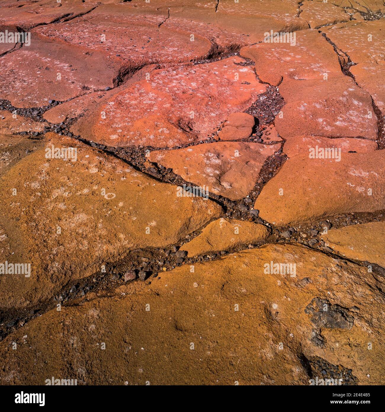 Colorful volcanic rocks with red and turquoise volcano soil with cracks ...