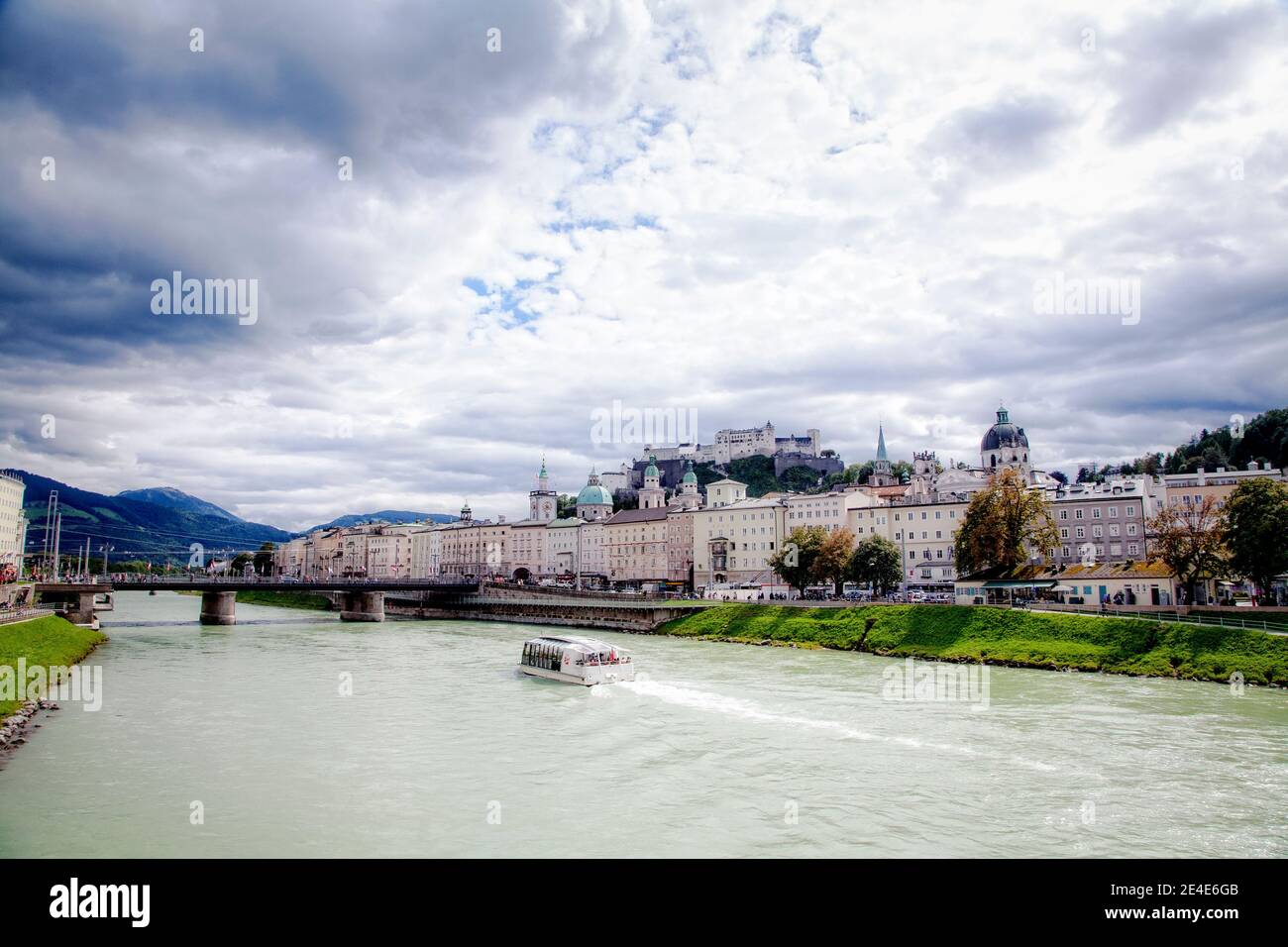 A tour boat navigates the Salzach River in Salzburg, Austria. Stock Photo