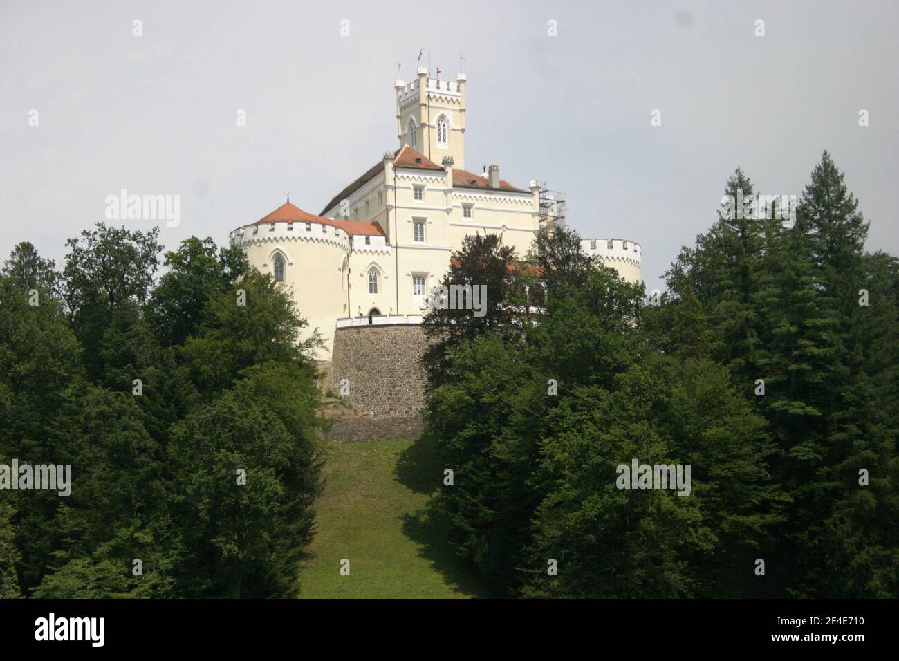 A medieval battlement surrounded by forest, on the top of the hill, on a cloudy day in summer Stock Photo