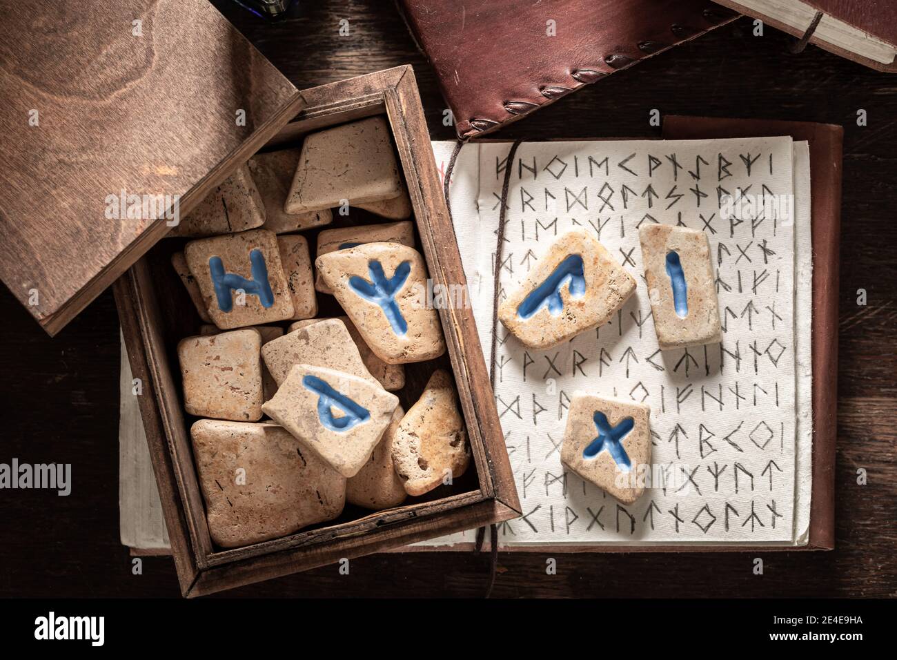 Rune stones made of Celtic language and vintage book on old table Stock ...