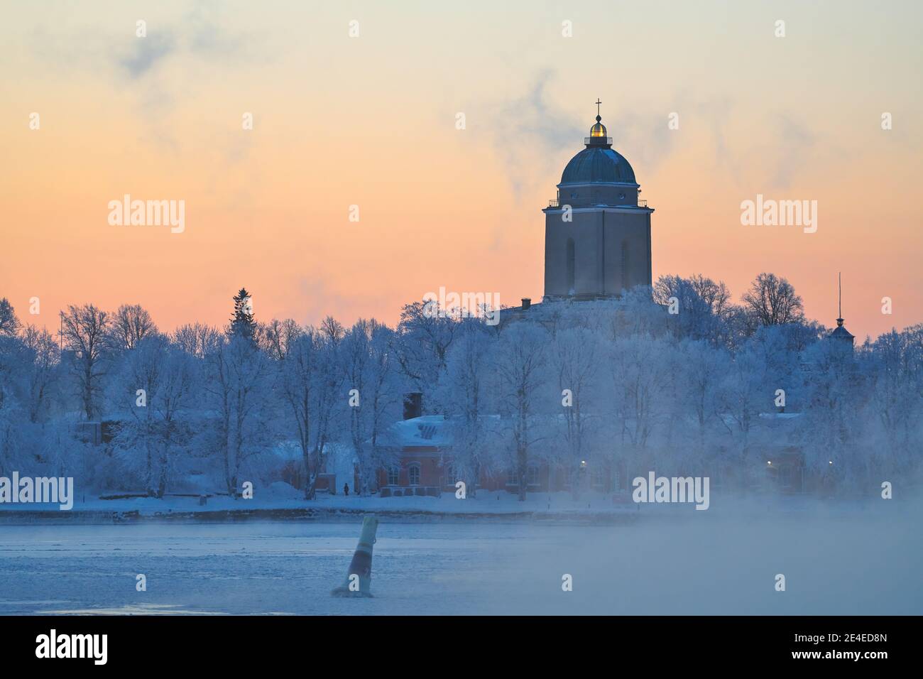 Arrival by ferry to the Suomenlinna fortress island on an extremely cold winter morning at sunrise with sea fog and icy Baltic sea, the Suomenlinna ch Stock Photo