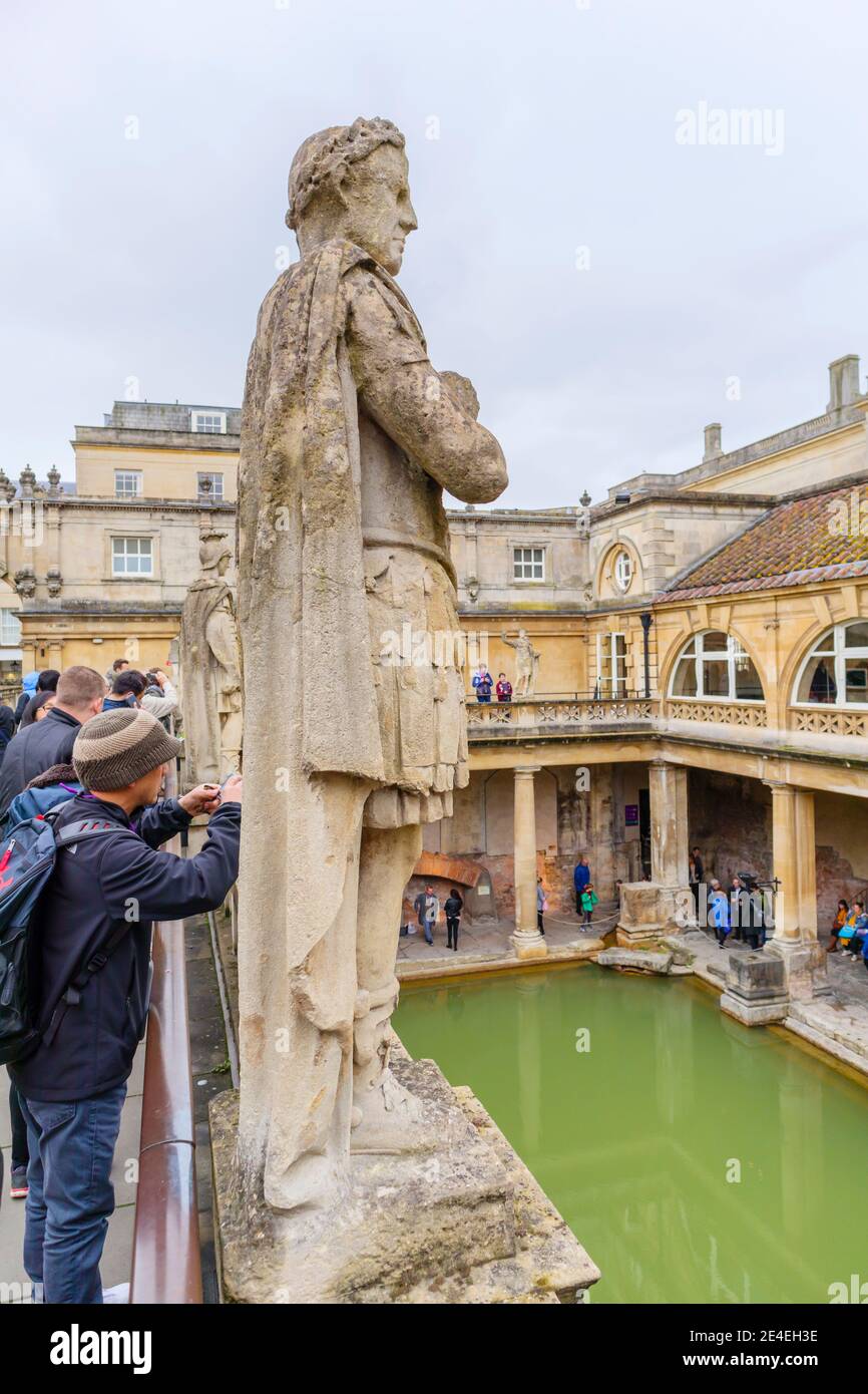 Statue of a Roman man overlooking the Great Bath in the Roman Baths museum, a tourist attraction in the City of Bath, Somerset, south-west England Stock Photo