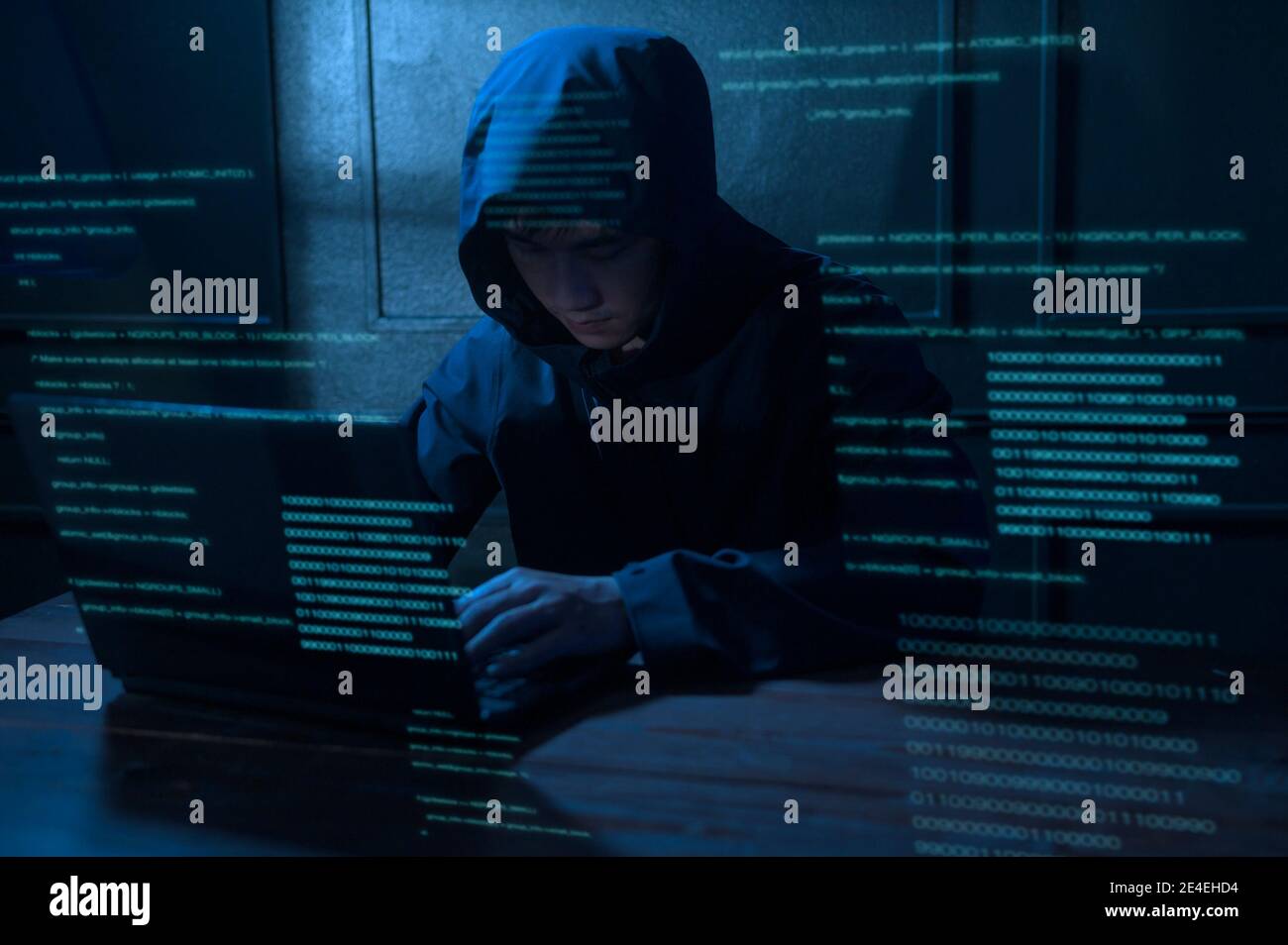 A Hacker is using laptop computer to steal data in the night Stock Photo
