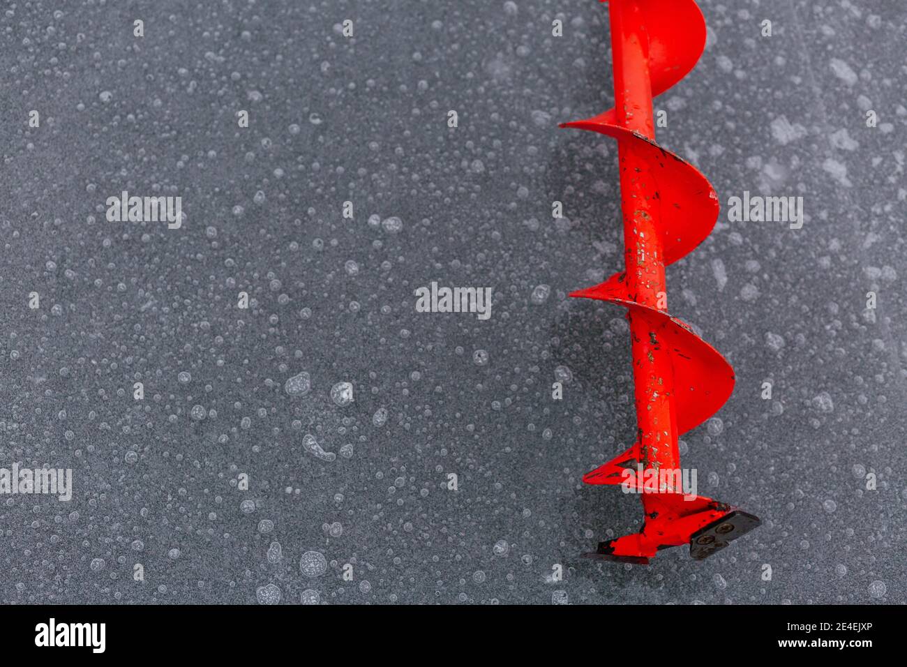 A yellow ice fishing sled with a blue ice auger (a helical screw blade) on  a frozen Minnesota lake Stock Photo - Alamy