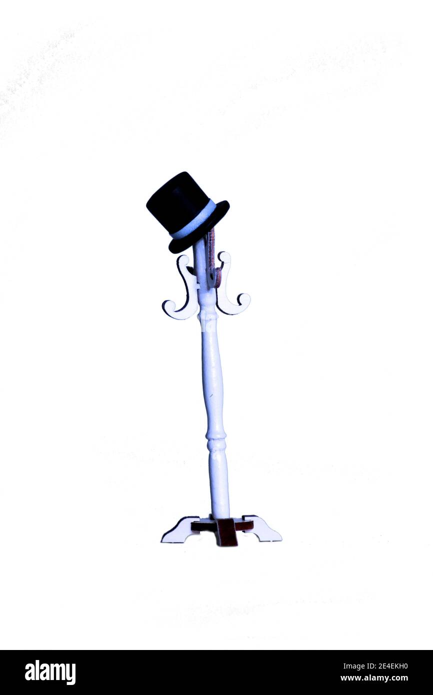 top hat on white coat rack isolated on white background. Doll house interior. Image contains copy space Stock Photo