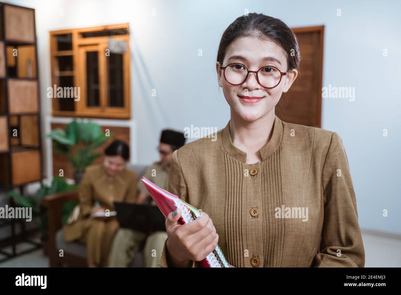 female teacher in civil servant uniform wearing glasses smiling while
