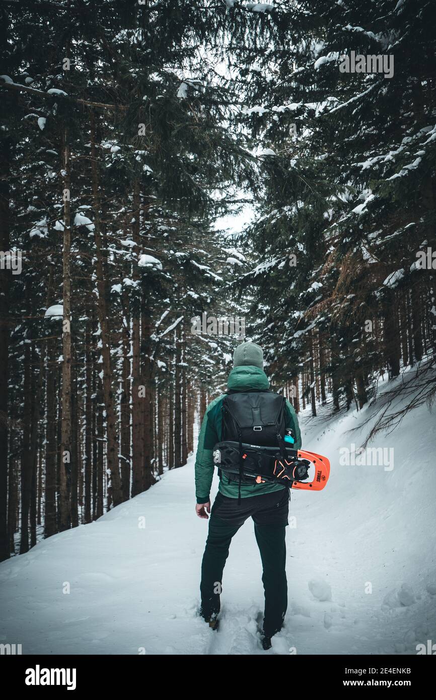 winter landscape forest backpack man / traveler in modern winter clothes in the forest