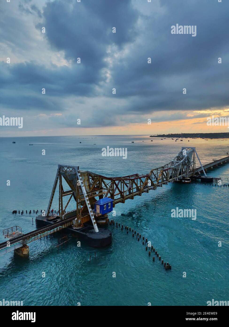 Vertical high angle shot of a large bridge on the blue water under a ...