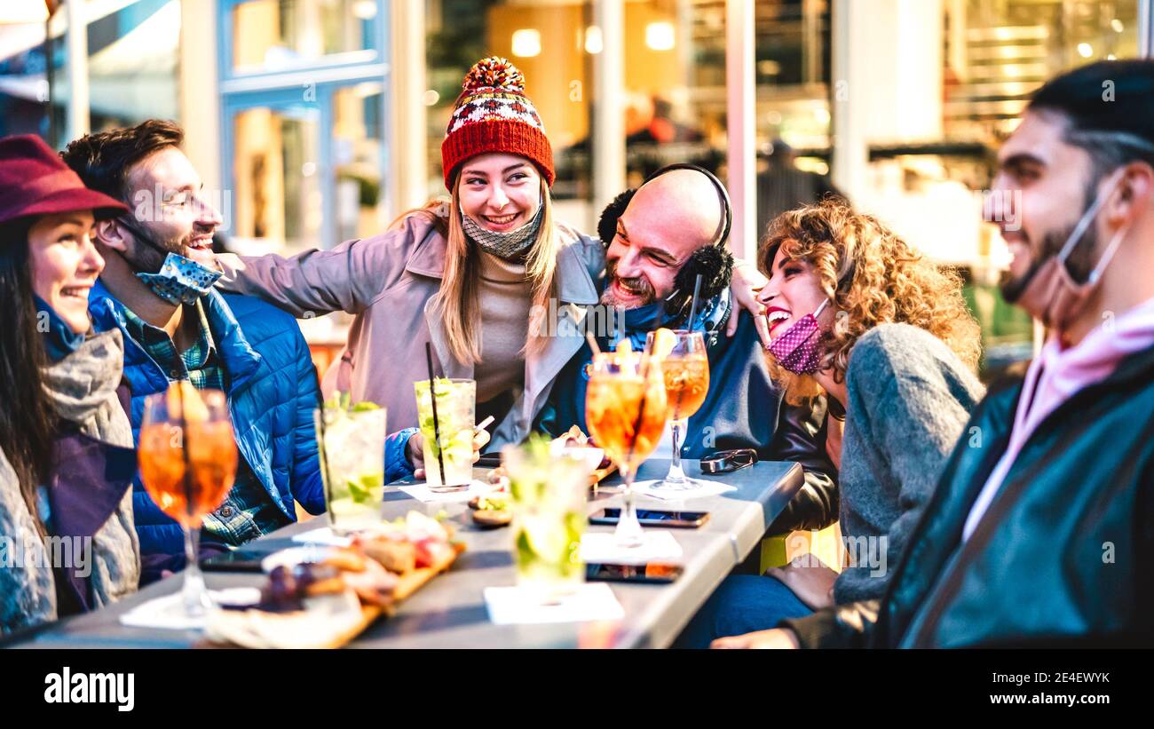 People joining cocktail happy hour at open air bar restaurant New