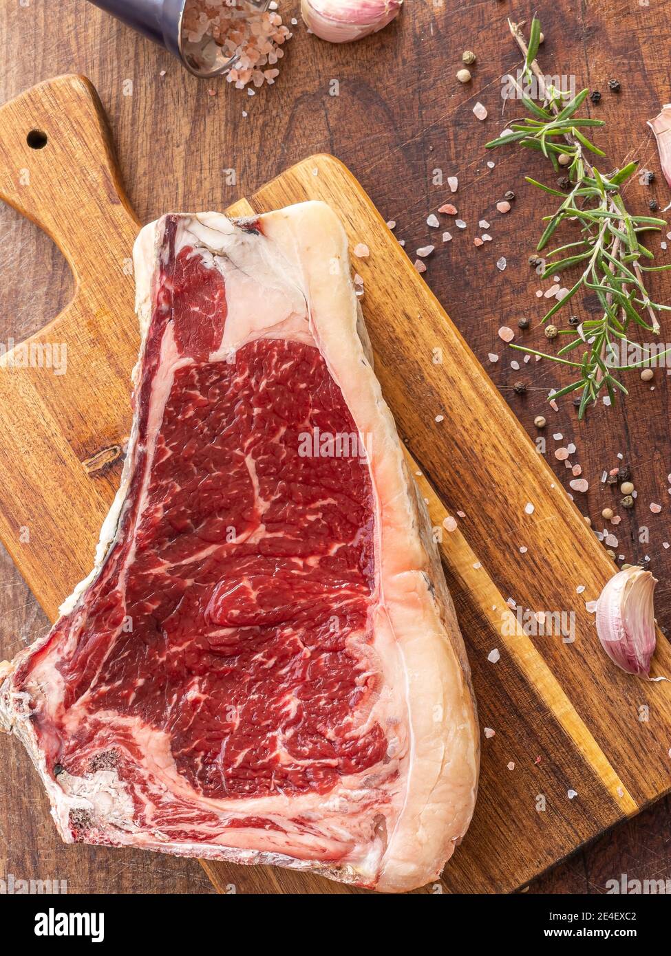 Fresh raw sashi beef steak with rosemary, himalayan salt, garlic and black pepper grains, ready to be cooked Stock Photo