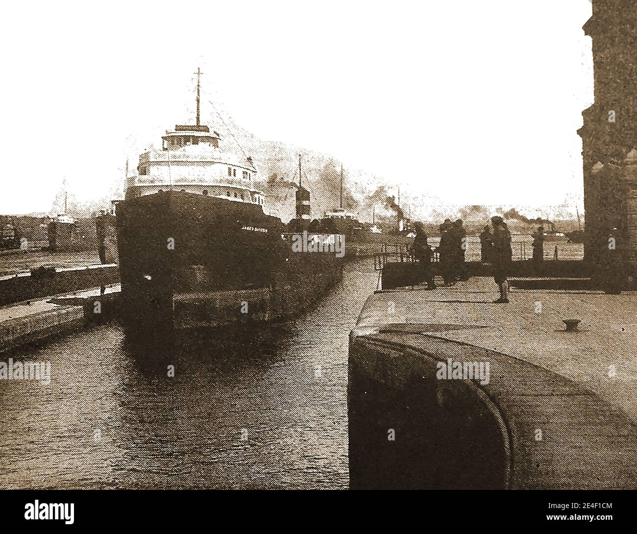 A 1940's printed photograph of ships passing through the Saulte Sainte Marie Canal (aka St. Marys Falls Canal, Soo Canal, Sault Ste. Marie canal or Sault Locks) which enable ships to travel between Lake Superior and the lower Great Lakes. The locks shut down during the winter from January through March but the period is used to inspect and maintain the locks. The first locks were opened in 1855 and were guarded by  U.S. Army's Central Defense Command in WWII. Stock Photo