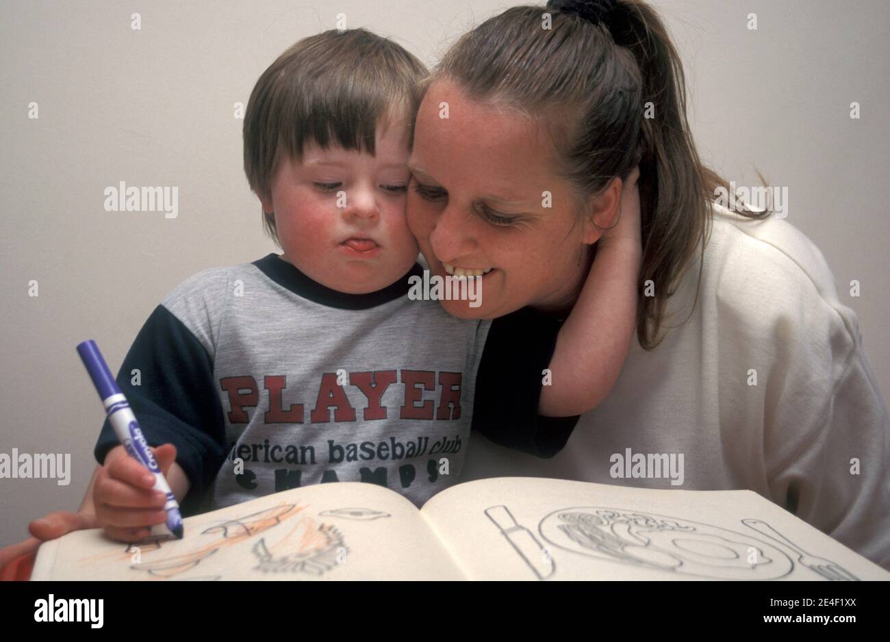 mother playing with her downs syndrome son Stock Photo