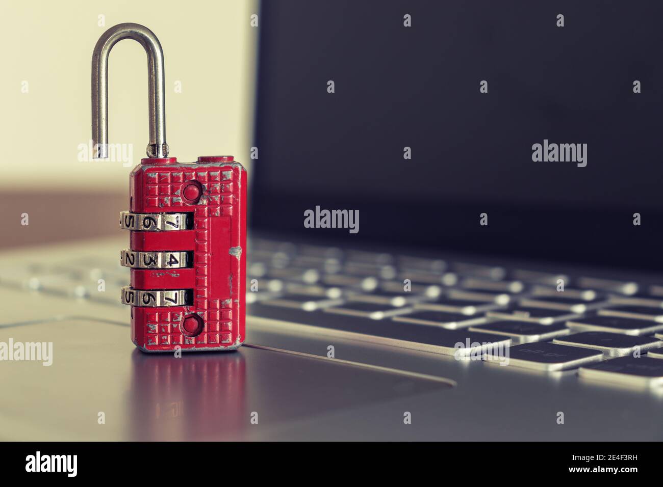 Red ruined padlock on a laptop keyboard. Computer security concept. Copy space. Stock Photo