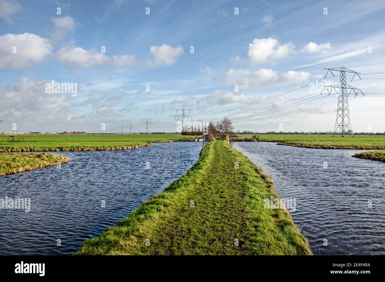 Steinse Tiendweg hiking trail in the polders east of Gouda, the Netherlands, with canals, ditches, meadows and electricity pylons Stock Photo