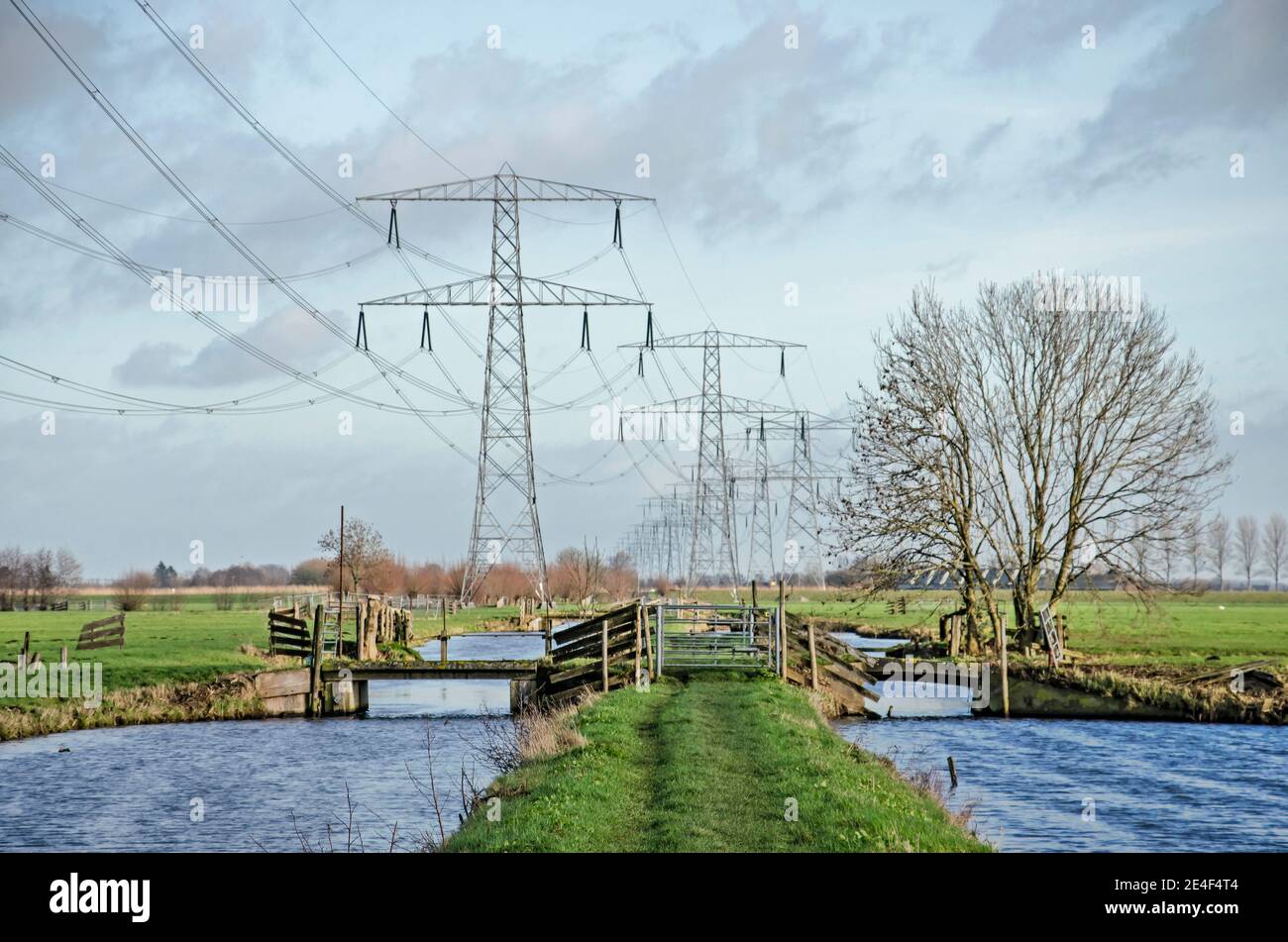 Steinse Tiendweg hiking trail in the polders near Gouda, The Netherlands crossing the trajctory of electricity pylons and power lines Stock Photo