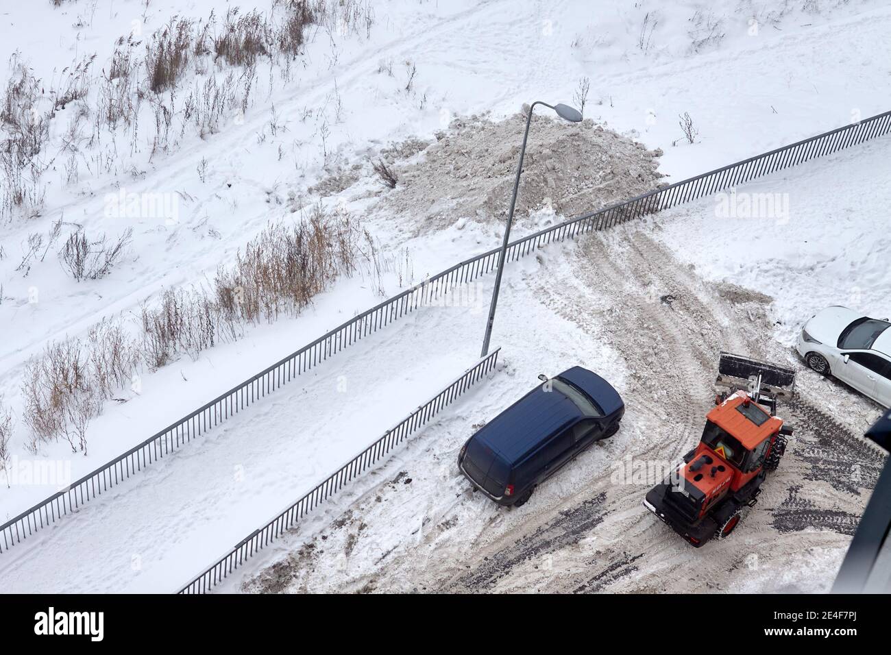 Top view of a snow-removing machine on a road near other cars Stock Photo