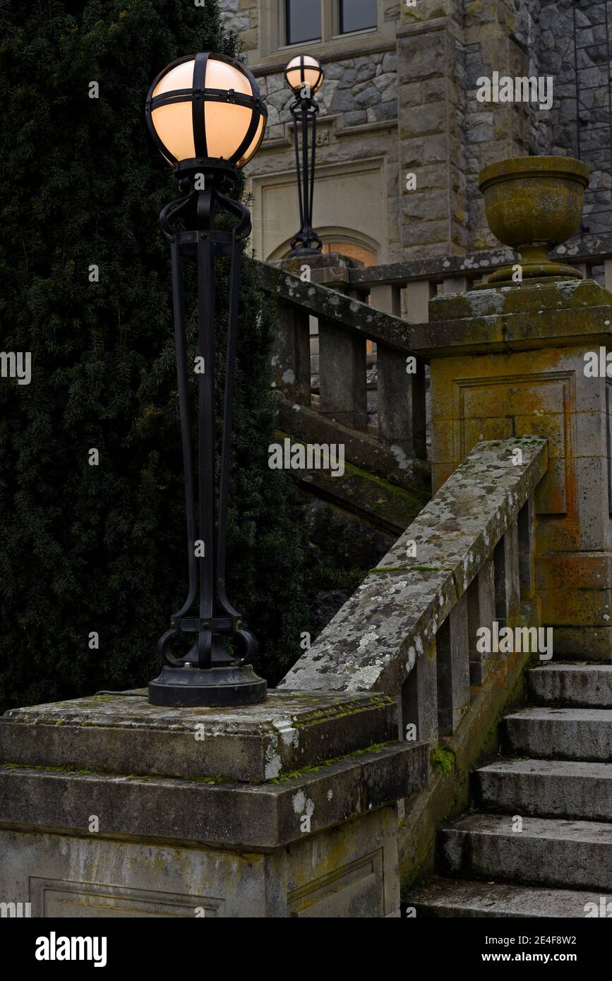 Lamps light the stairs outside Hatley Castle on Vancouver Island, British Columbia, Canada Stock Photo