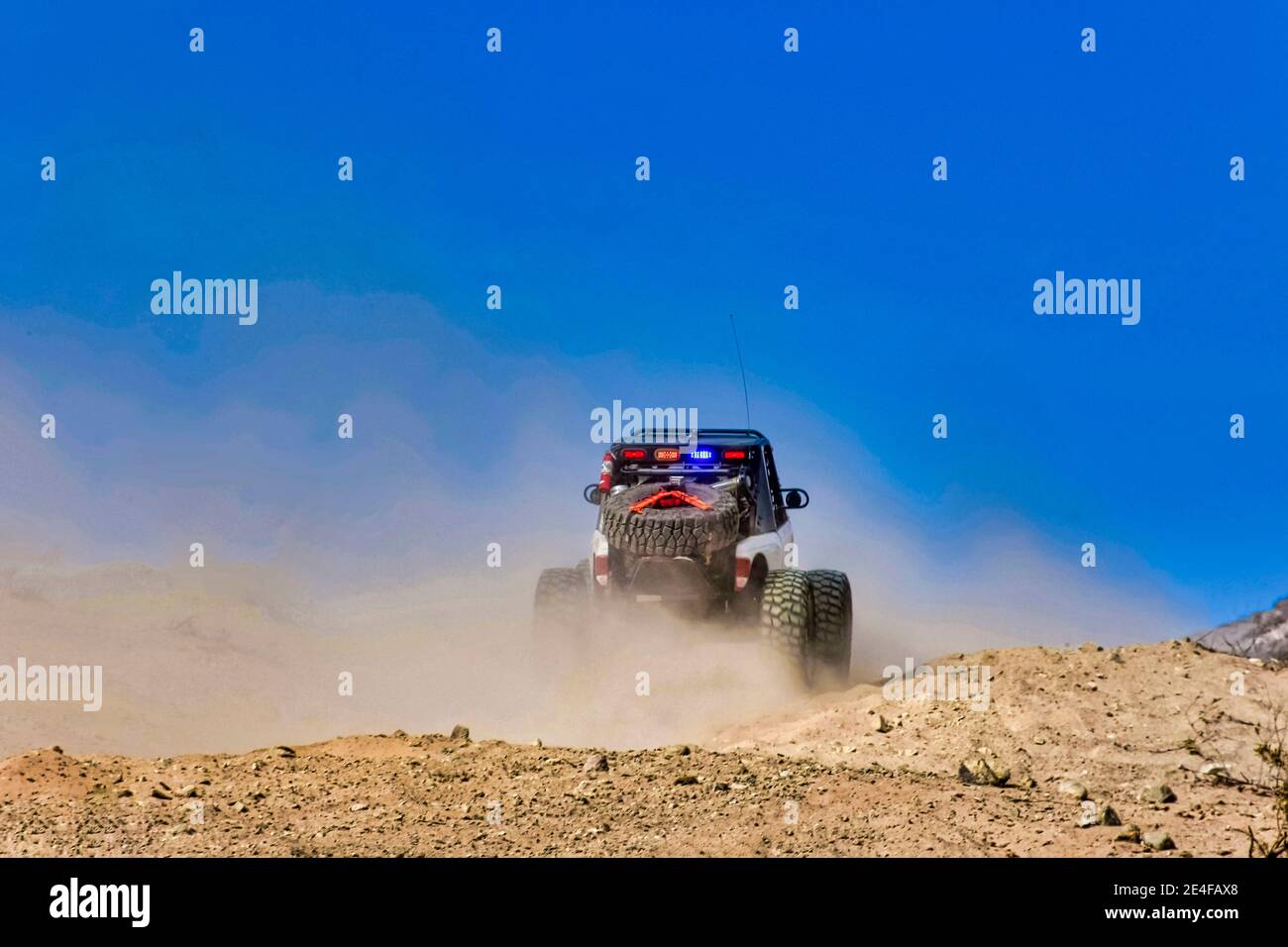 An ULTRA4 off road racing car careers though the desert during the