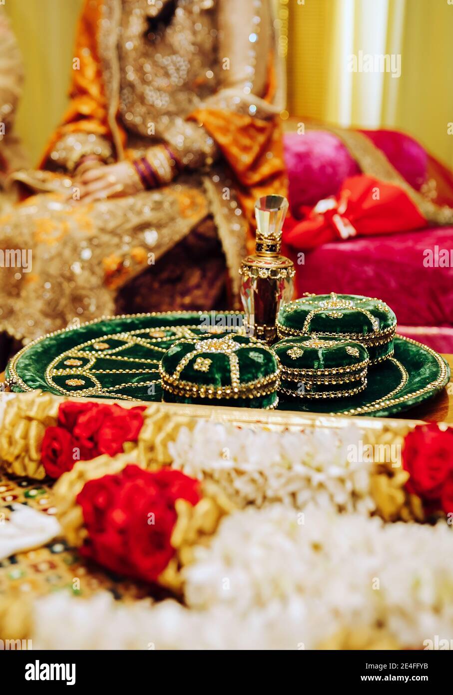 Indian pakistani henna wedding party background with traditional flowers,  mehndi green velvet plate and bride in yellow dress embroidered with gems  Stock Photo - Alamy