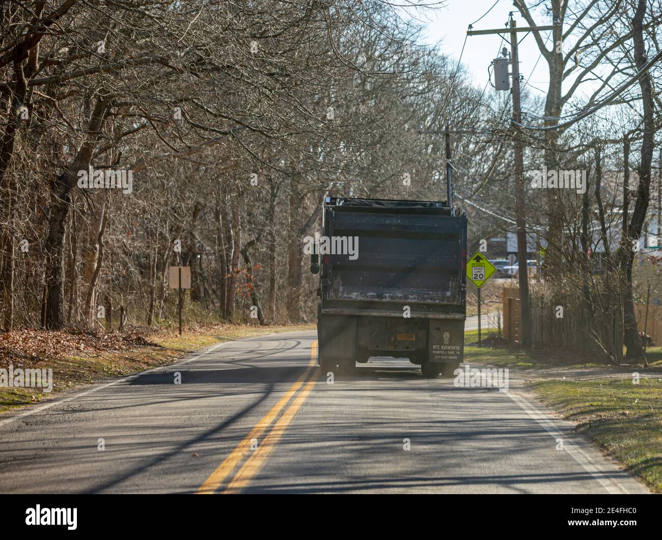 Large dump truck traveling down a two lane road Stock Photo